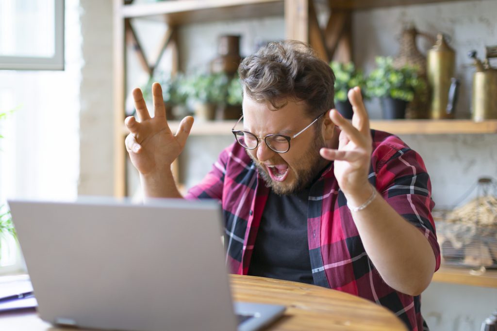 man yelling at laptop