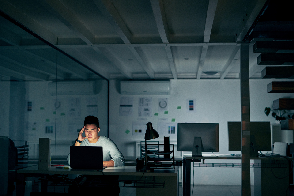 young businessman looking stressed in front of a computer